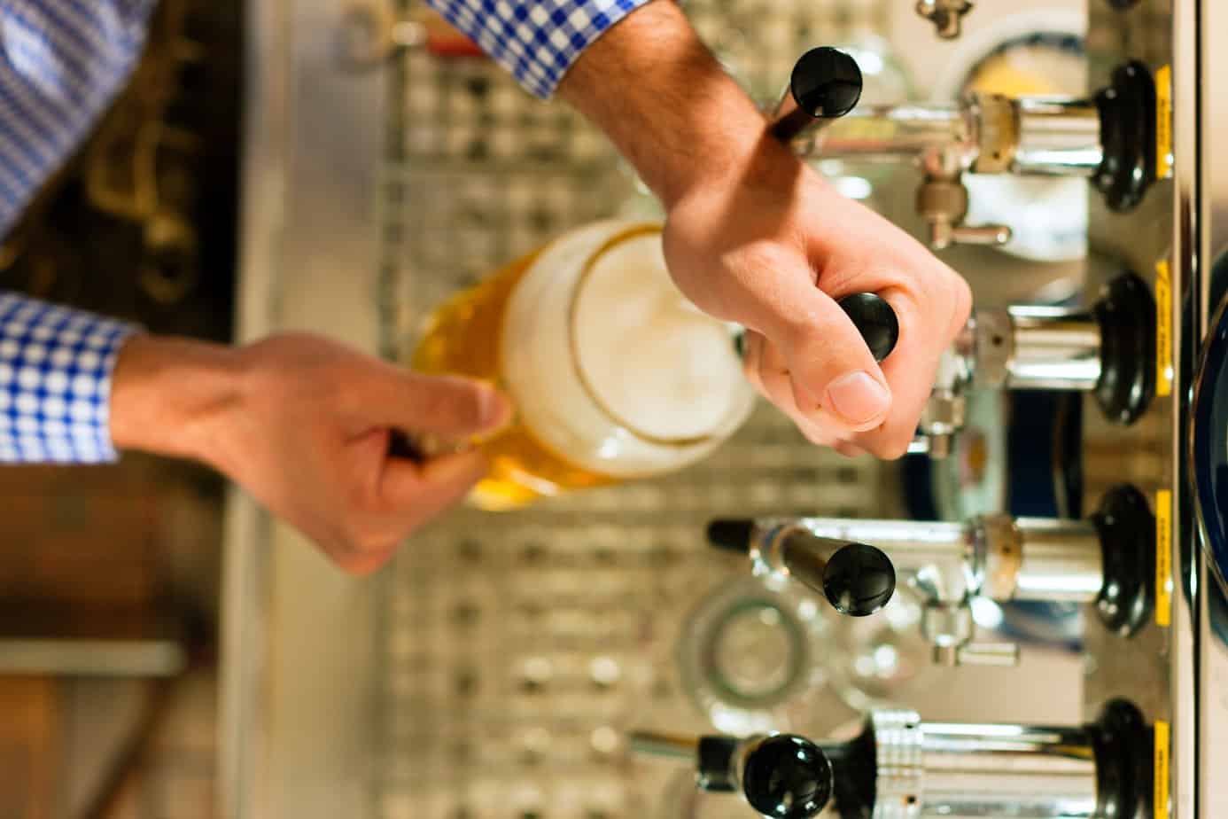 man pouring beer in kegerator